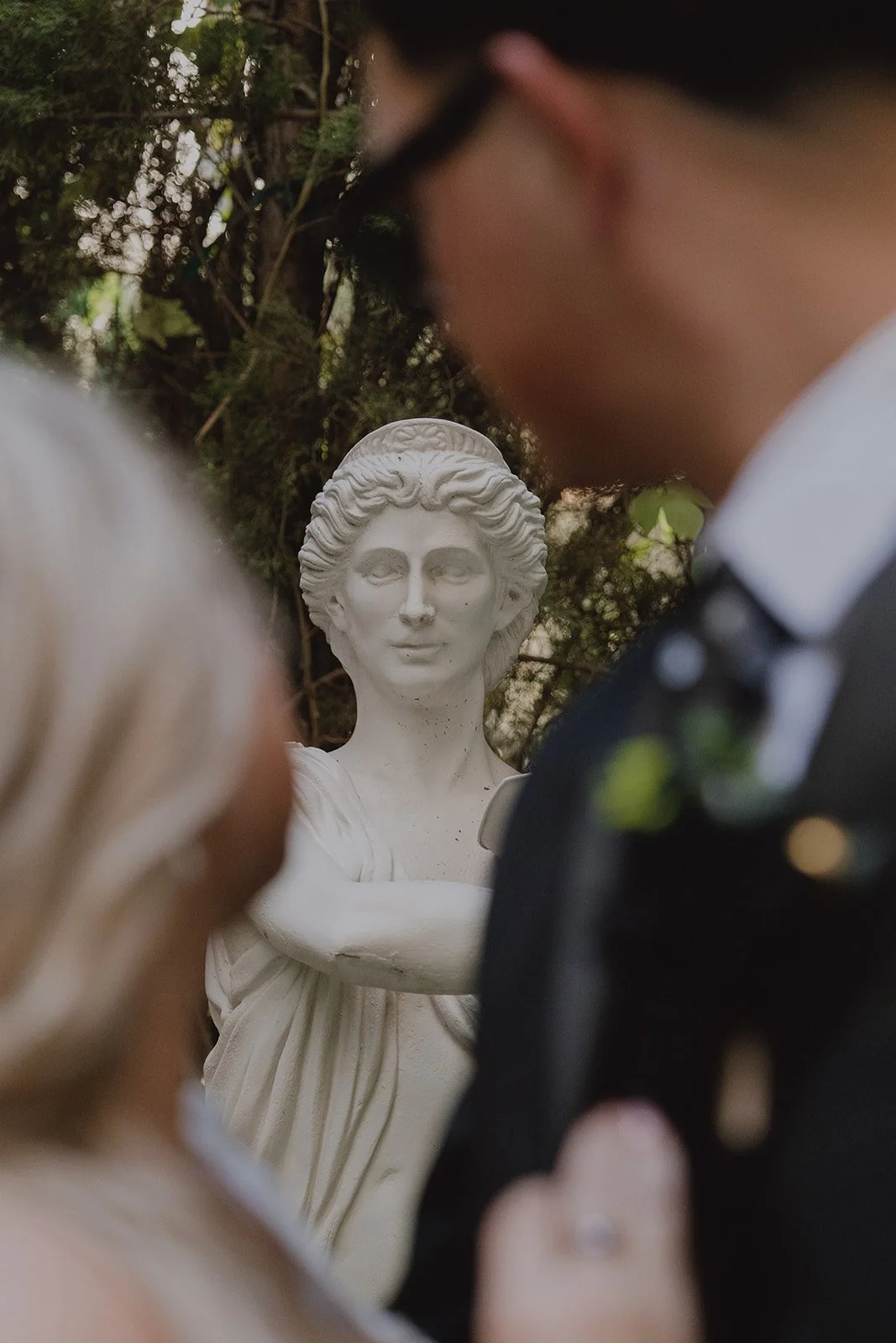 Close up of a bride and groom posing with the statues at Caesars Palace Venus Garden