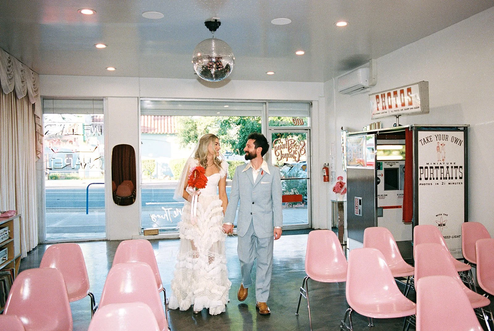 Couple walking down the aisle together for their vintage Sure Thing Chapel elopement in Las Vegas.