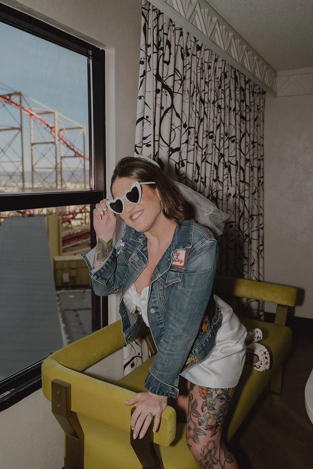 Bride posing in her heart shaped sunglasses and jean jacket as she gets ready for her Las Vegas wedding.