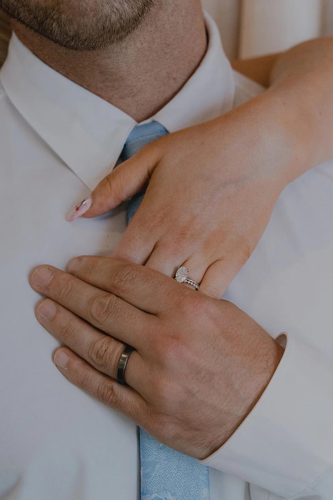 Close-up of the bride’s hand resting on the groom’s chest showing wedding rings during their Las Vegas micro wedding.