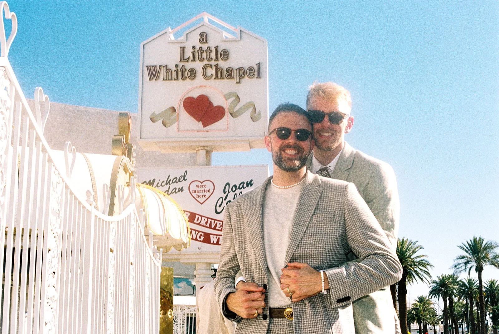 Couple posing outside of a Little White Wedding Chapel for their 35mm film elopement photos.