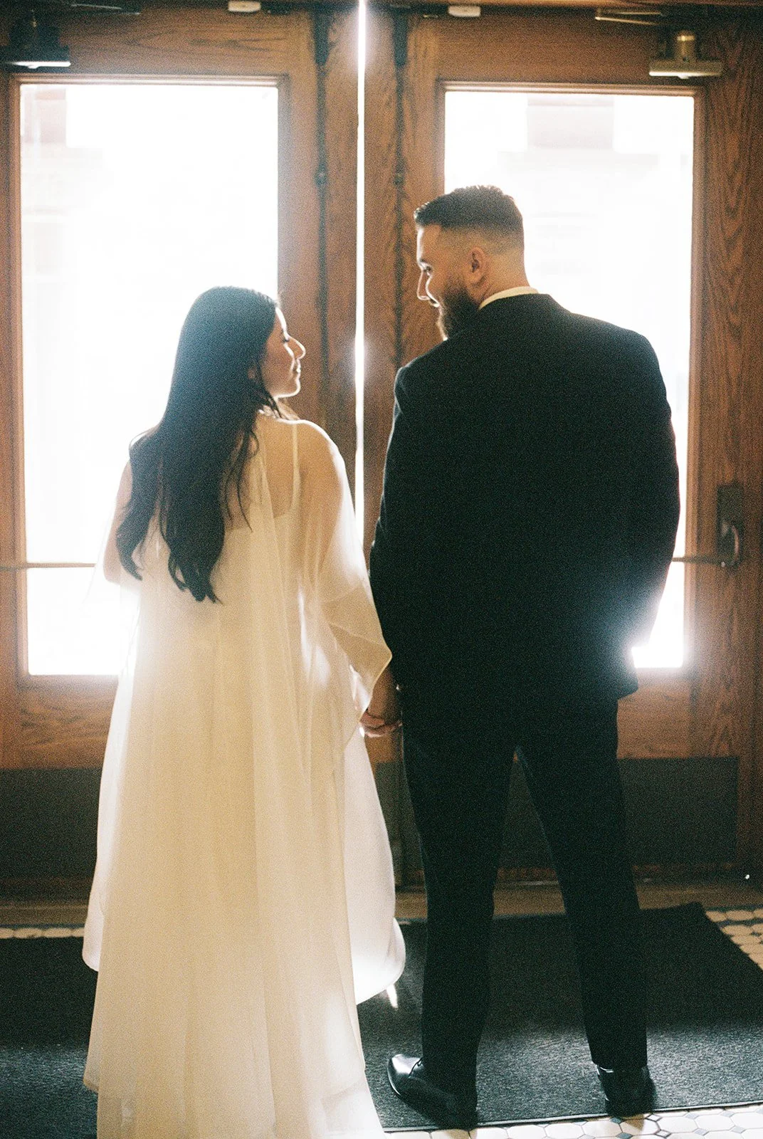 35mm film photo of a couple about to walk out of the courthouse together.