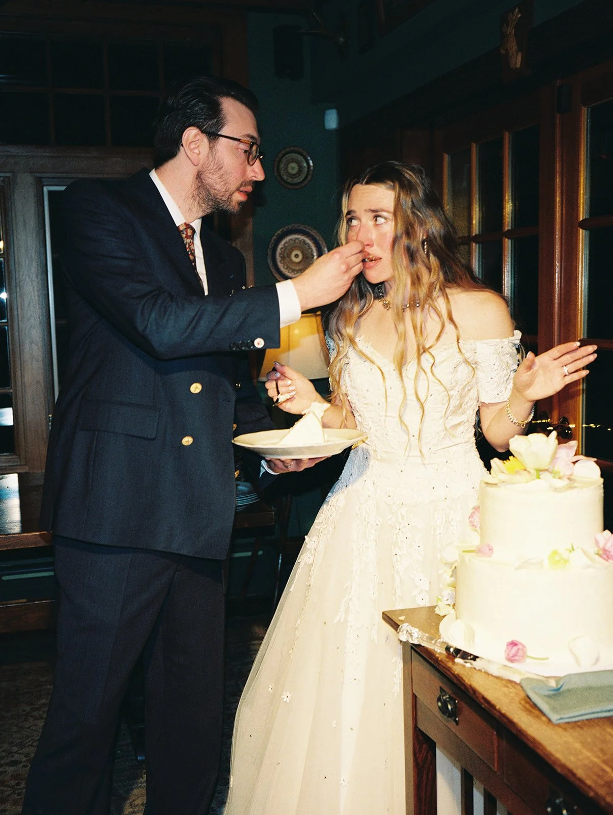 Candid film photo of the groom feeding the bride cake during their Deer Mountain Inn wedding reception.
