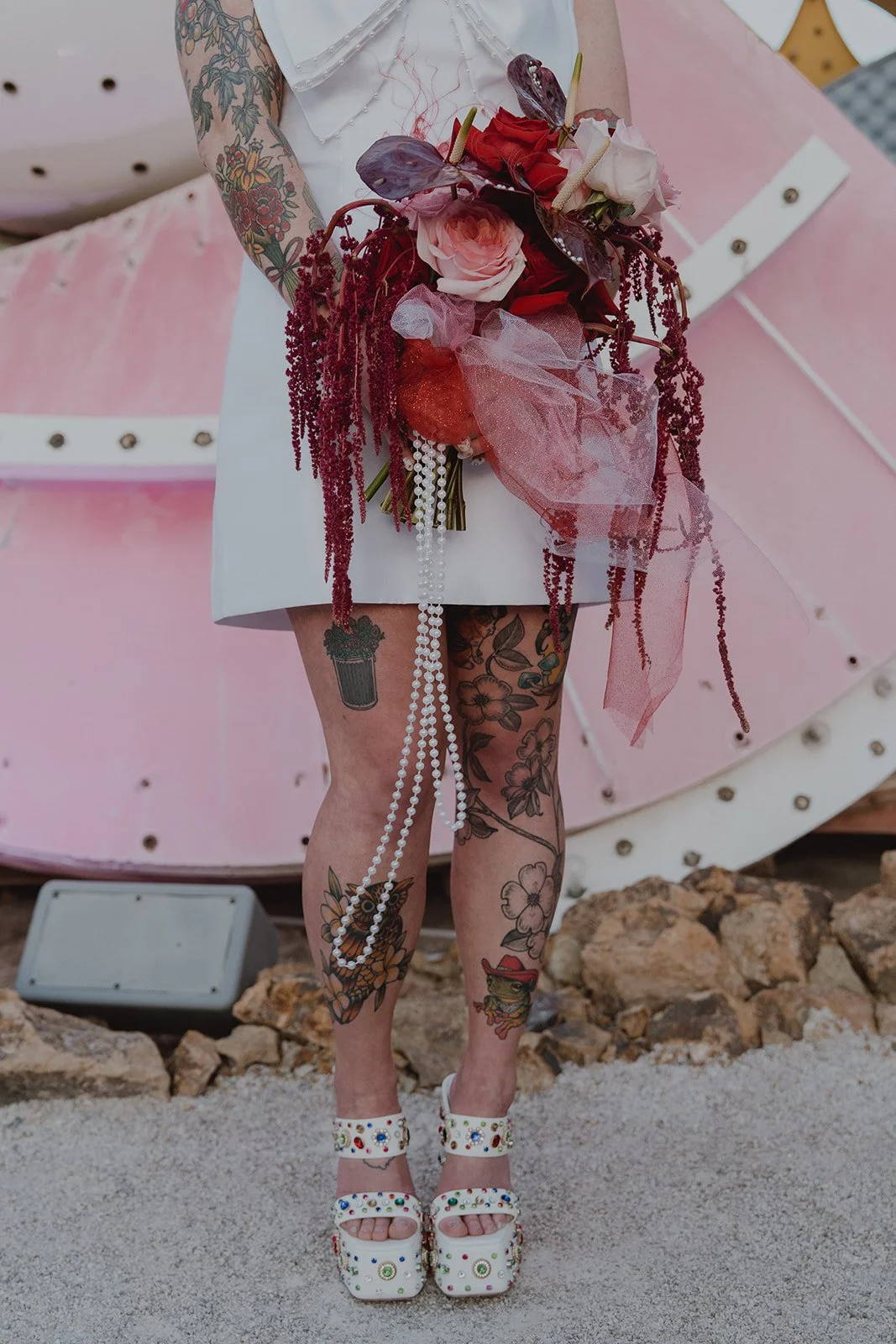 Close up shot of the bride holding her bouquet and wearing bedazzled pumps for her Neon Museum wedding in Las Vegas.