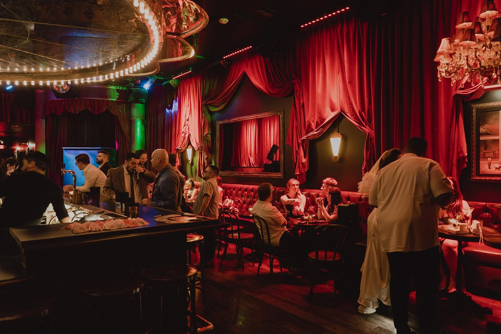 Moody bar interior with red velvet curtains and guests dining at Cheapshot Las Vegas reception.