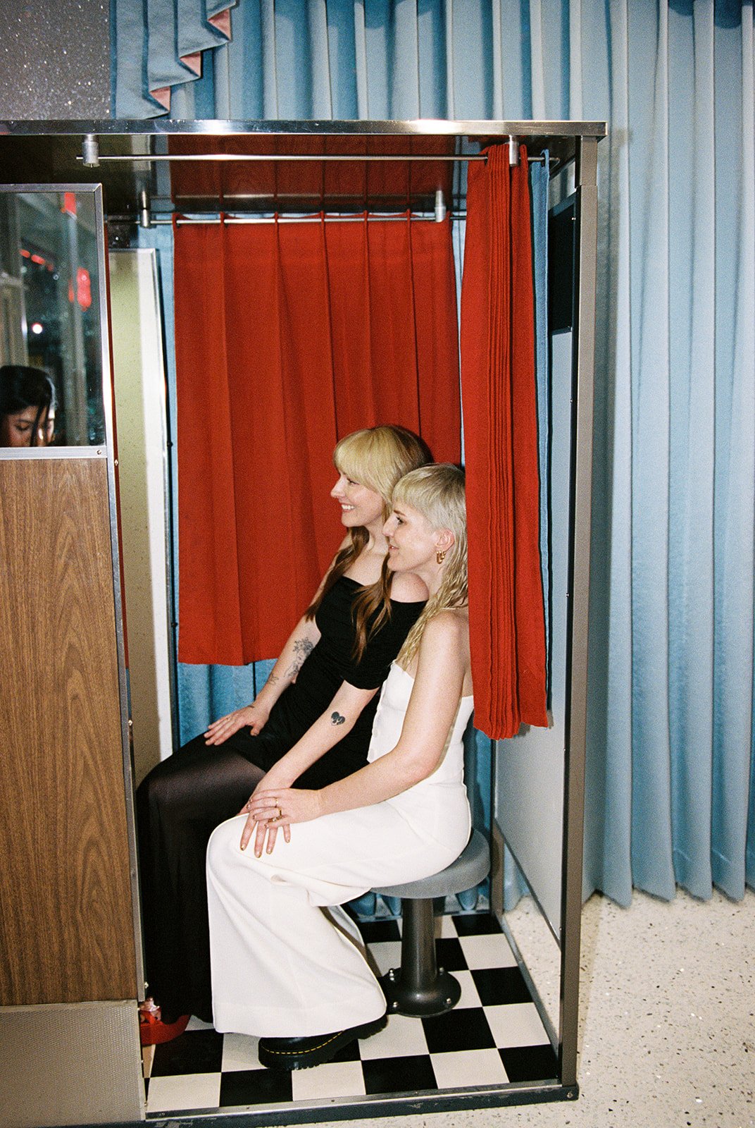 Couple posing inside the vintage photobooth at Sure Thing Too.