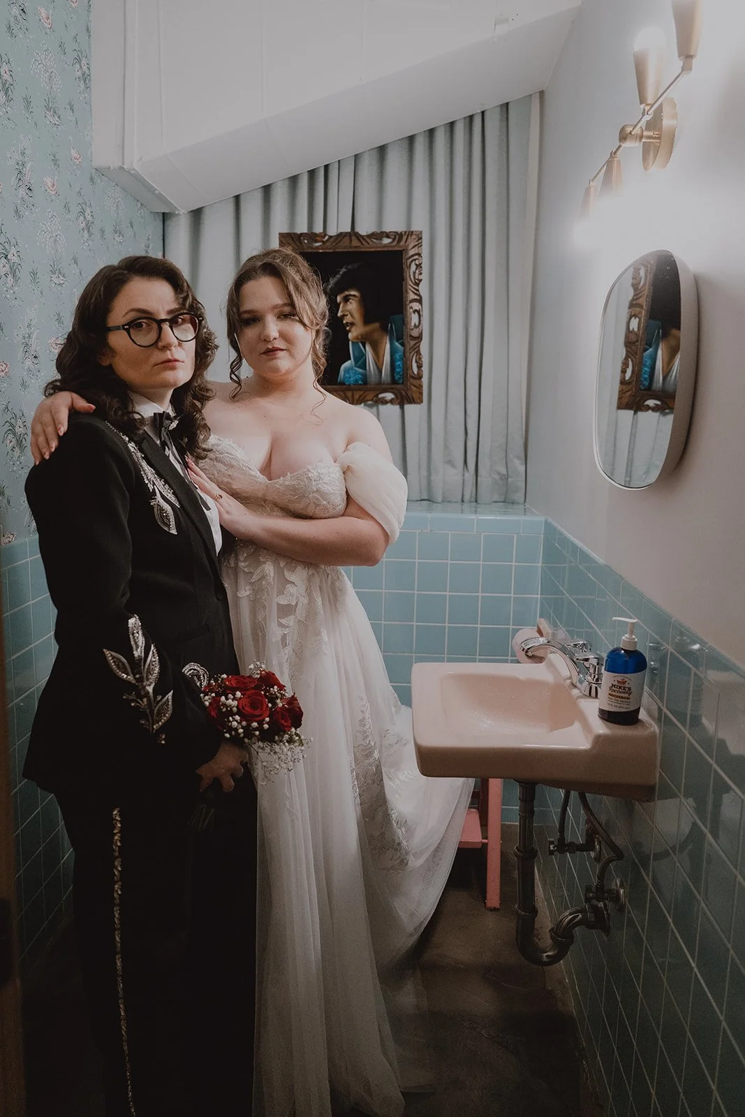Couple taking editorial wedding portraits in the blue tiled bathroom at Sure Thing Chapel.