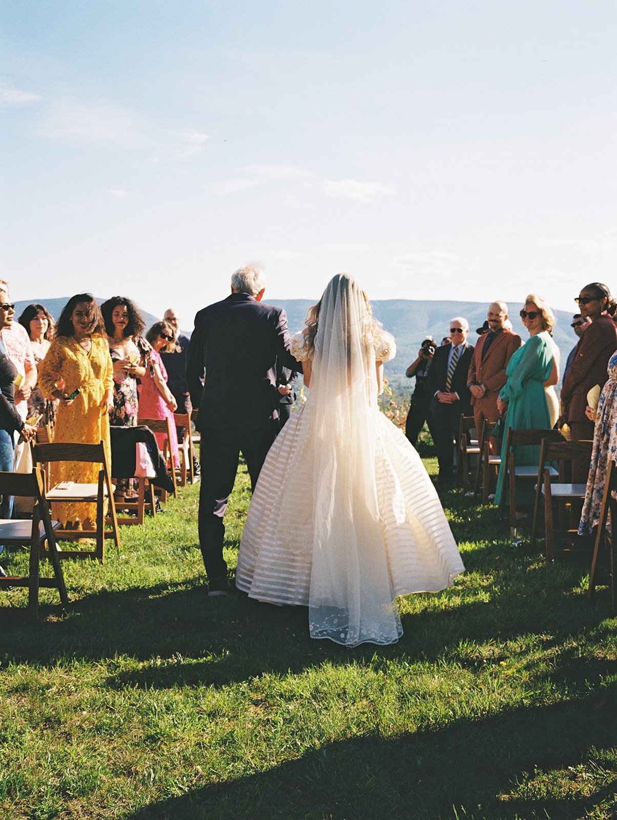 Bride being walked down the aisle during her Northern Catskill Mountain wedding ceremony.