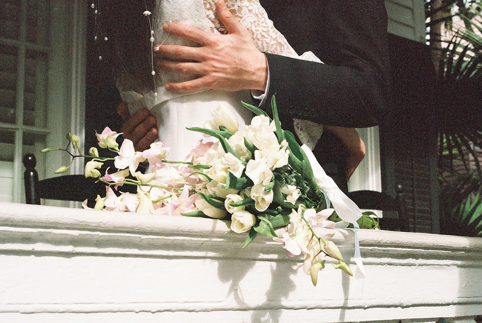 Close up shot of a bride and groom holding each other on the porch at Old Town Manor in Key West, Florida.