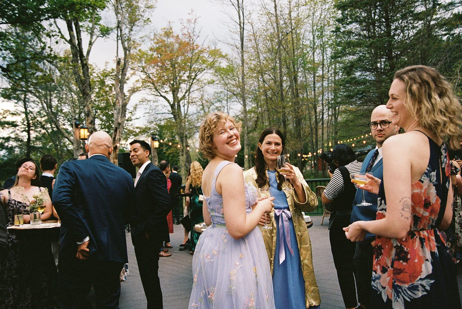 Candid film photo of guests laughing and enjoying drinks during a Deer Mountain Inn wedding cocktail hour.