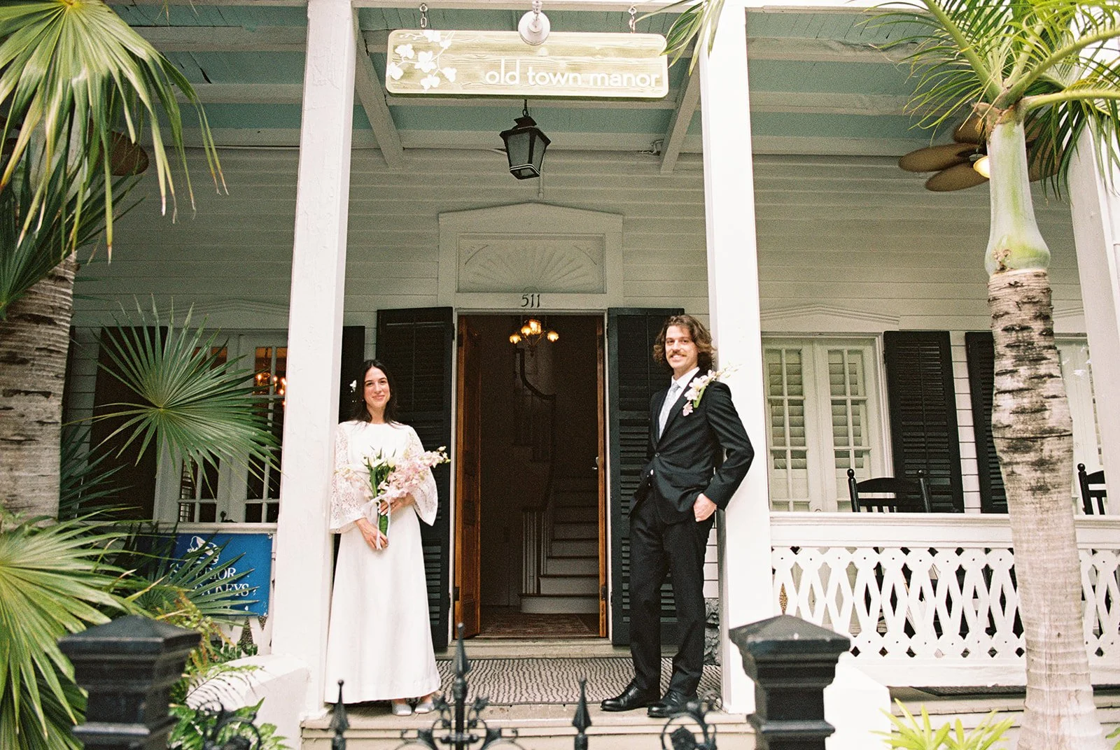 Bride and groom posing across from one another at Old Town Manor in Key West, Florida.