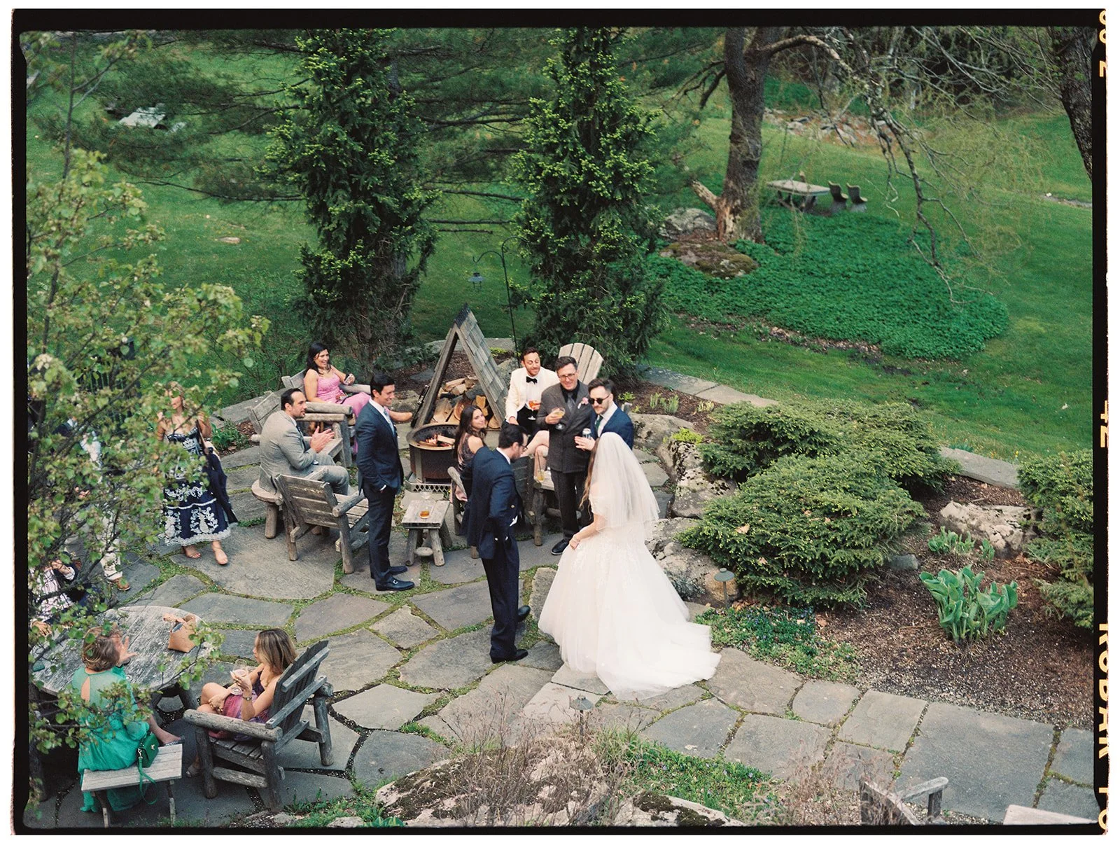 Bride and groom mingling with guests during their cocktail hour by the outdoor firepit at Deer Mountain Inn.