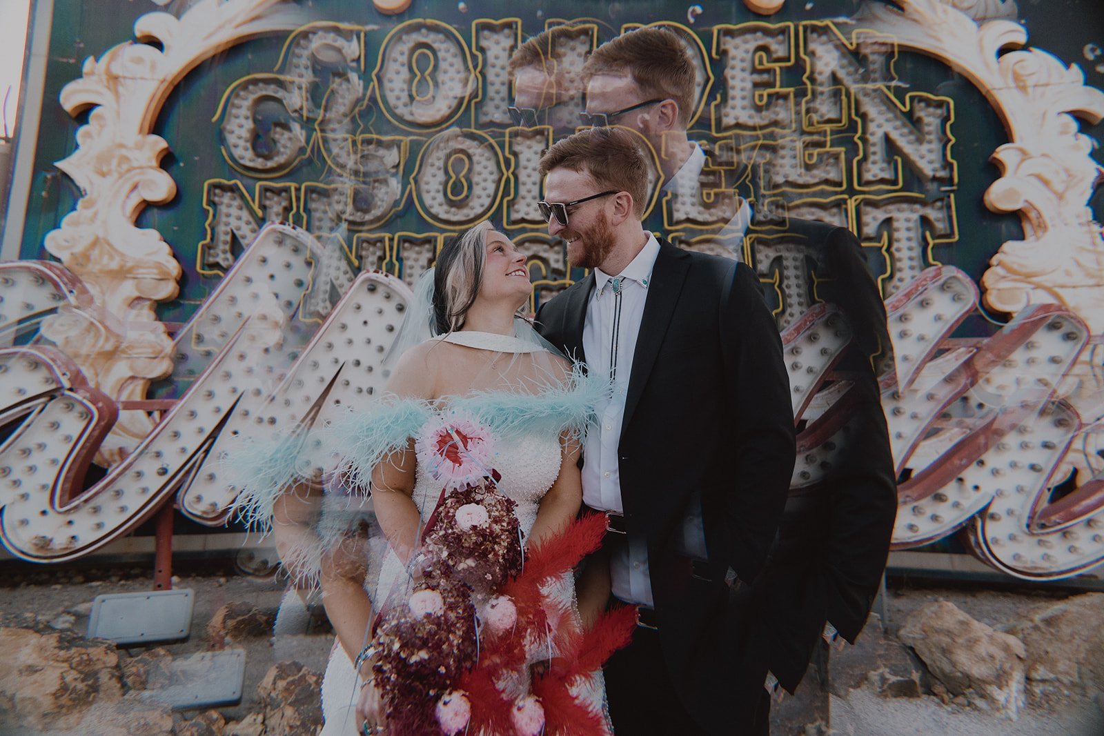 Bride and groom posing in front of the Golden Nugget sign at The Neon Museum.