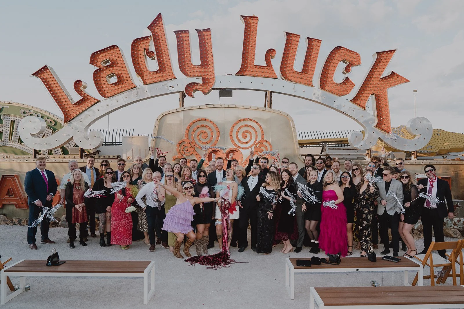 Big group shot with the bride, groom, and their wedding guests at The Neon Museum in Las Vegas.