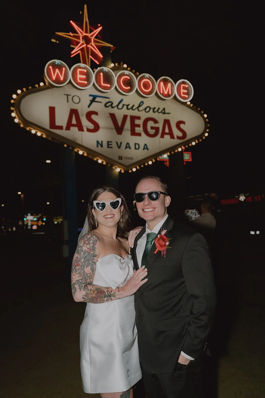 Bride and groom smiling together under the Welcome to Fabulous Las Vegas sign after their Las Vegas micro wedding.
