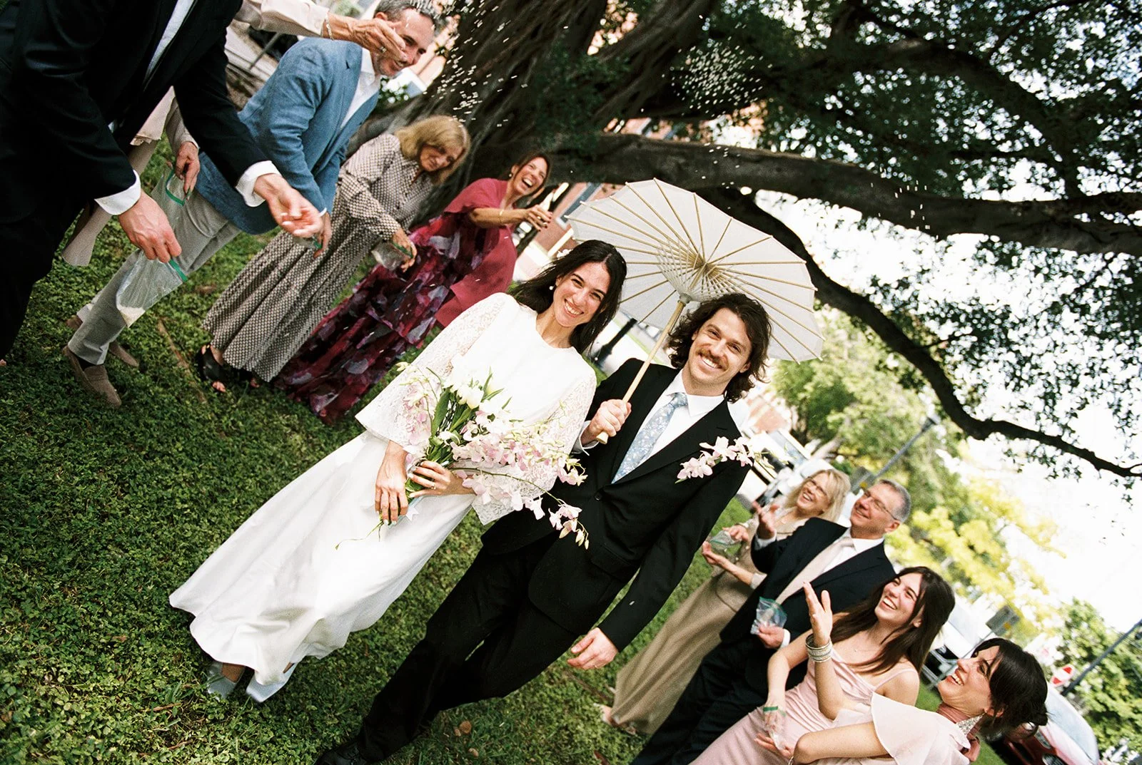 Couple walking during a petal toss outside ofMonroe County Courthouse in Key West, FL.