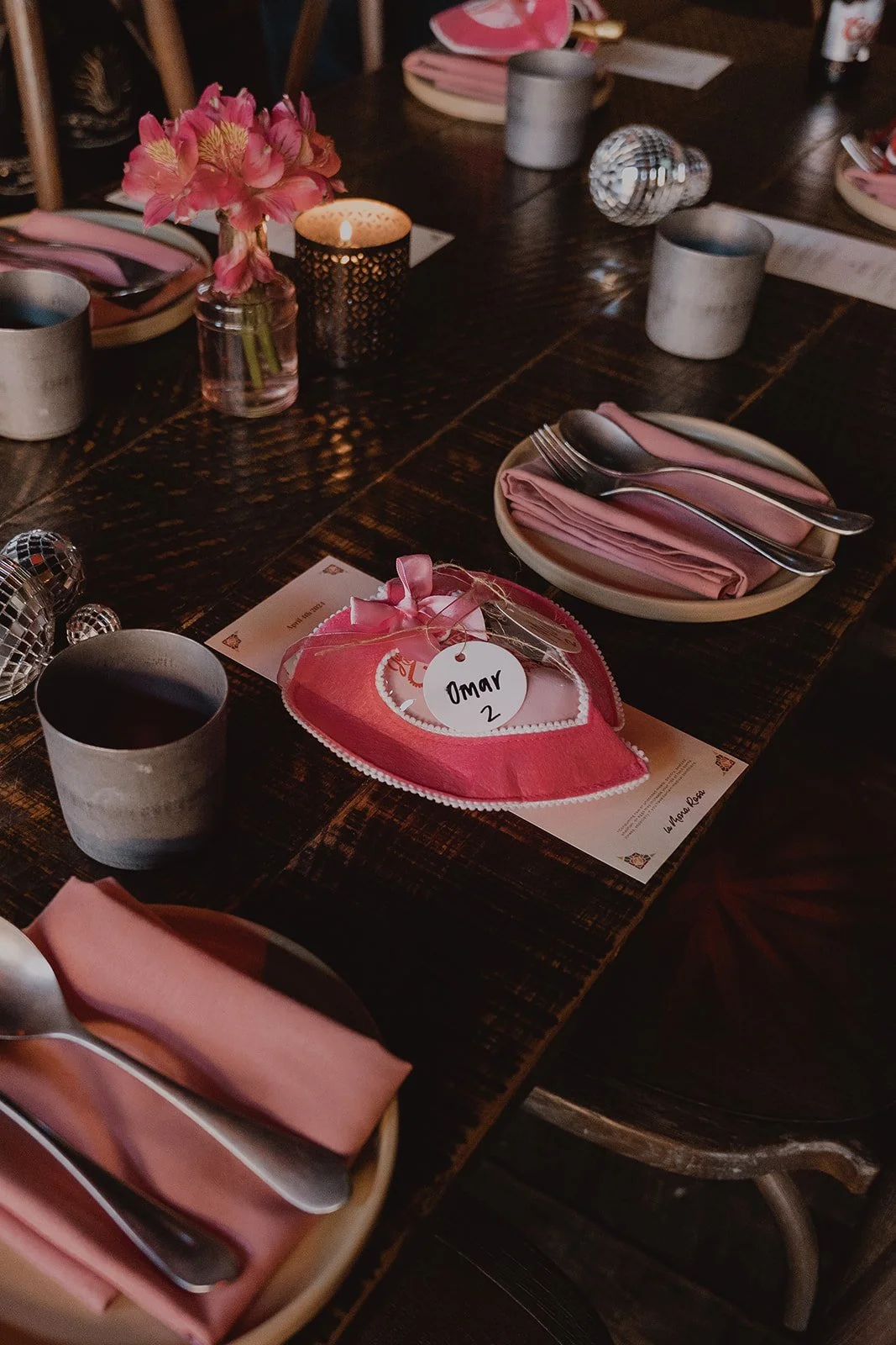 Bride and groom wedding reception table details with pink heart favor and candles at La Mona Rosa Las Vegas.