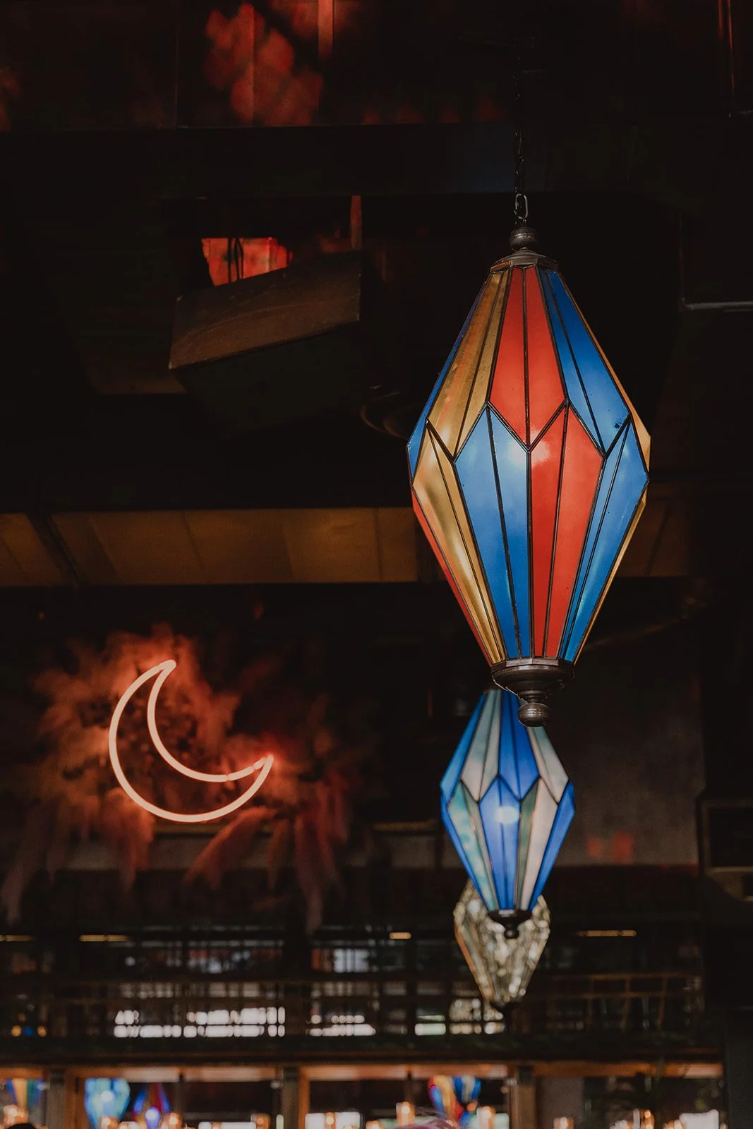 Colorful hanging lantern lights and neon moon inside La Mona Rosa Las Vegas reception space.