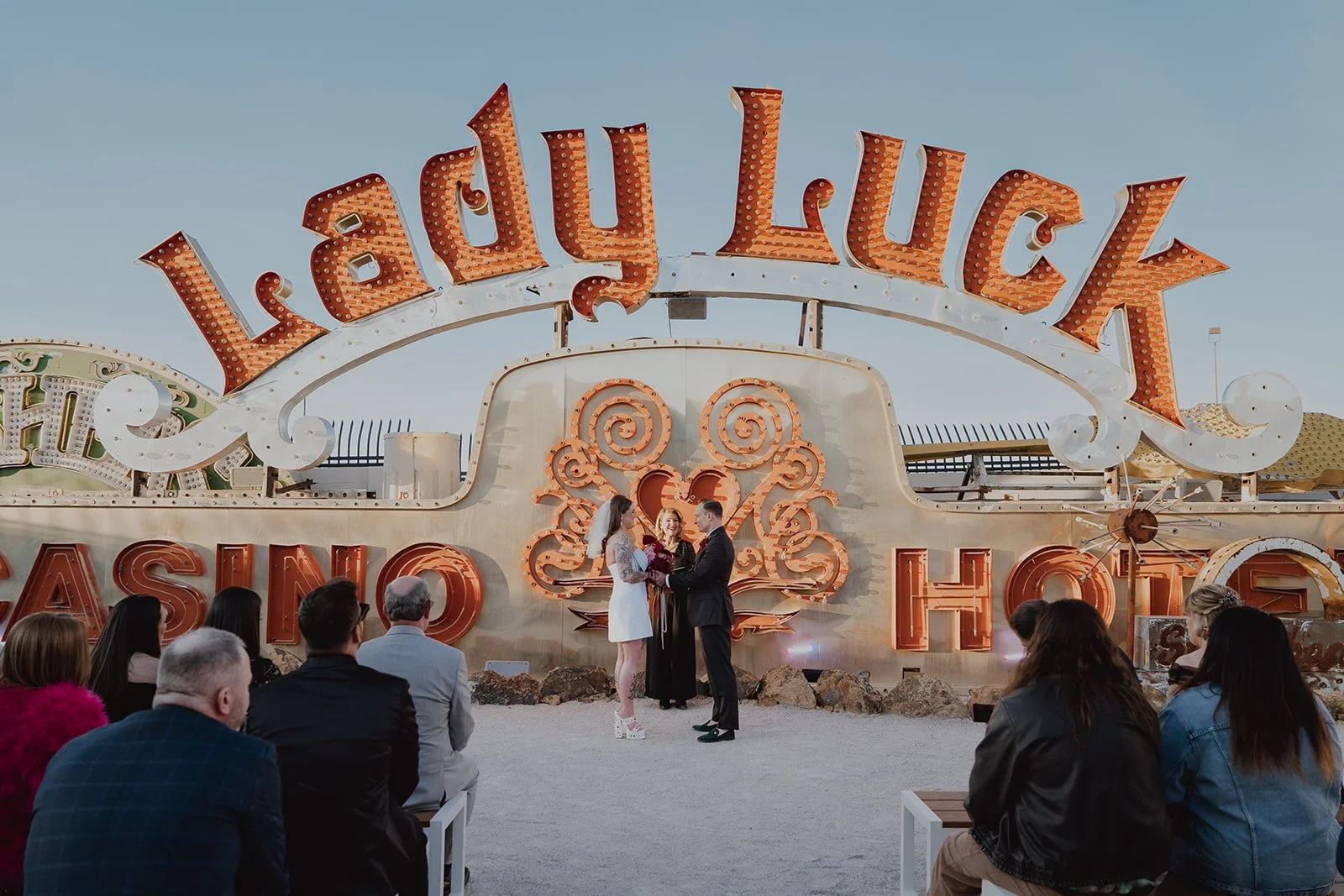 Bride and groom holding hands during their Neon Museum Las Vegas wedding ceremony.
