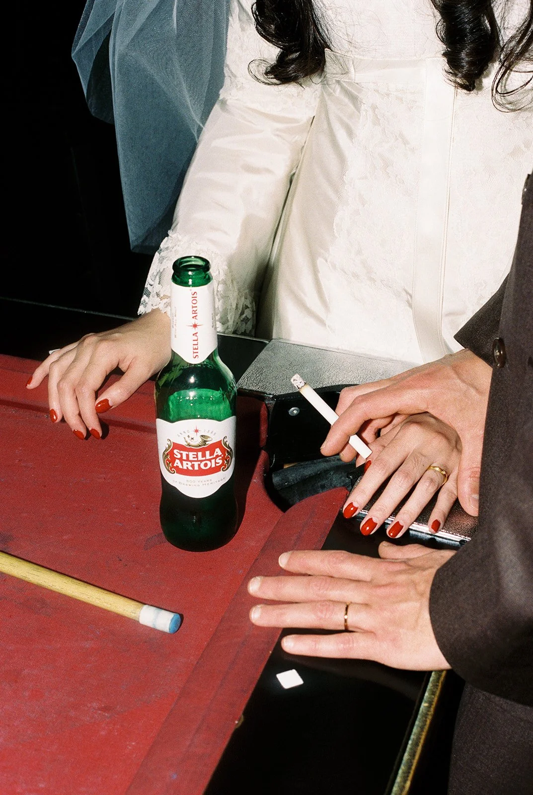 Close up shot of a bride and groom having drinks and cigarettes inside Dino's Bar in Las Vegas.