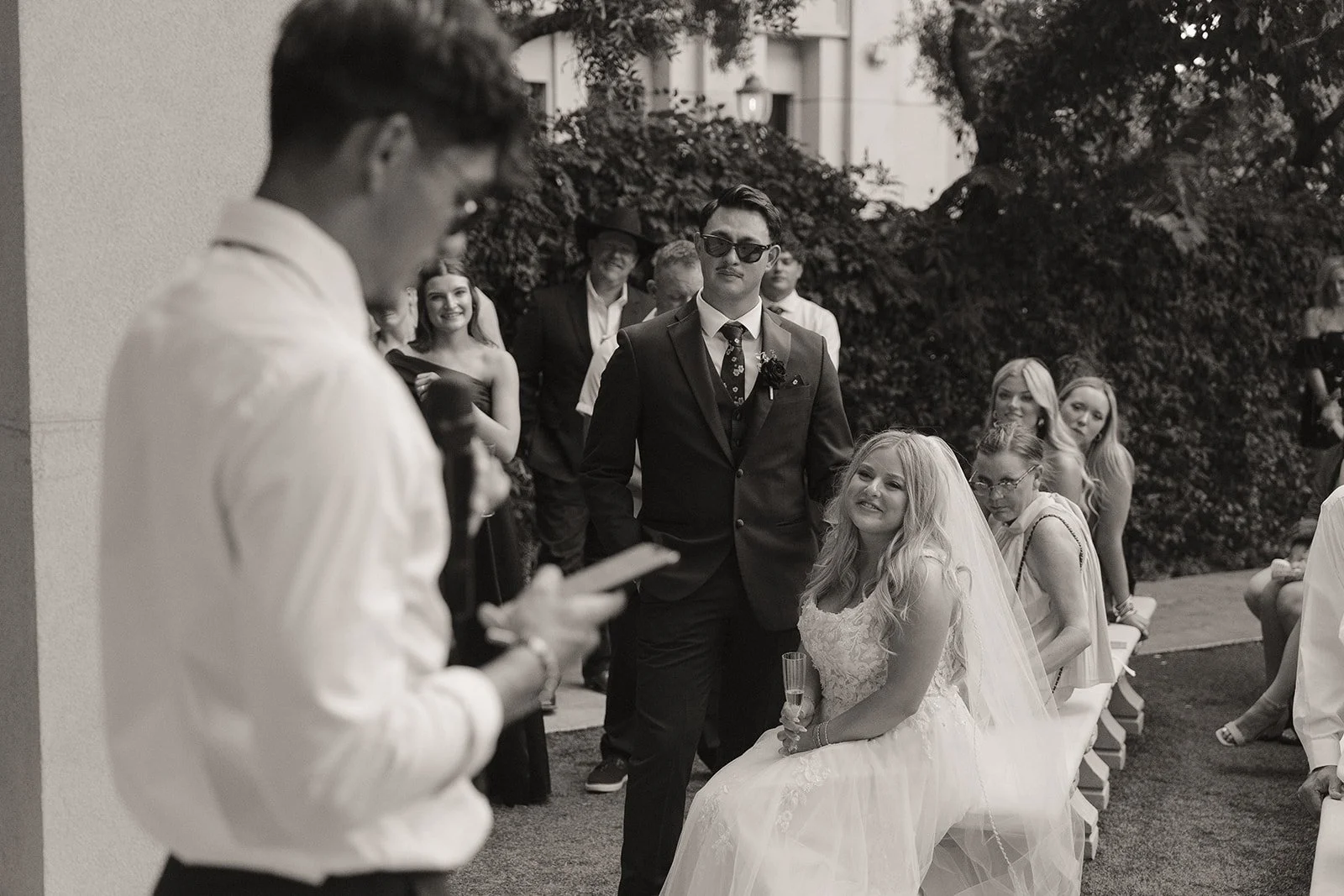 Black and white photo of as bride and groom listening to speeches during their Las Vegas micro wedding