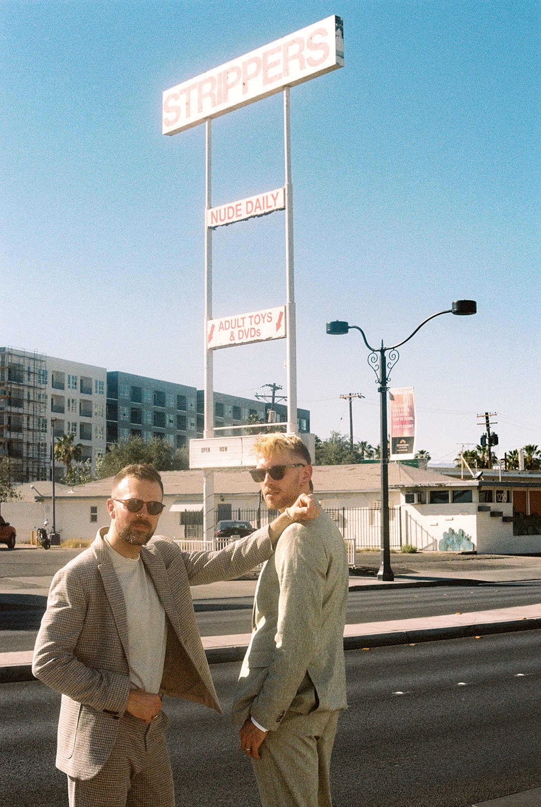 Couple posing in front of the stripper sign on 35mm film.