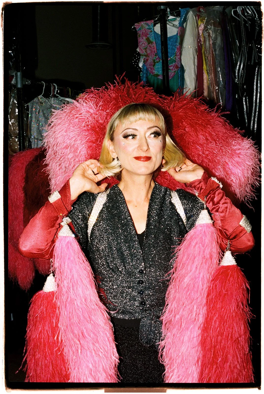 Zoey Goto wearing a pink feathered showgirl costume during the Showgirl Bootcamp Experience in Las Vegas, photographed on 35mm film.