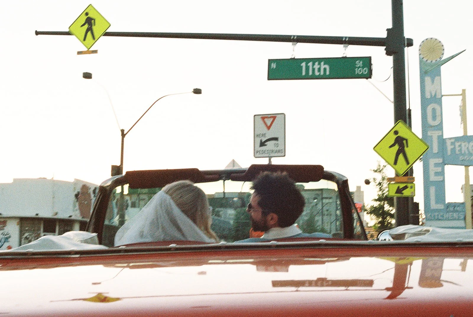 Bride and groom sitting in the red convertible facing towards 11th street in Las Vegas.