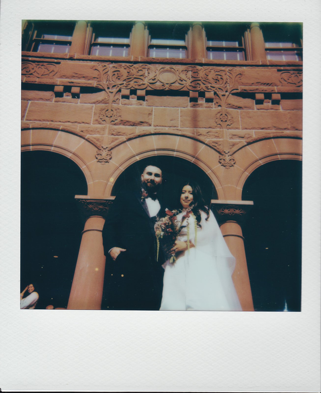 Couple posing on the steps of Old Orange County Courthouse on Polaroid.