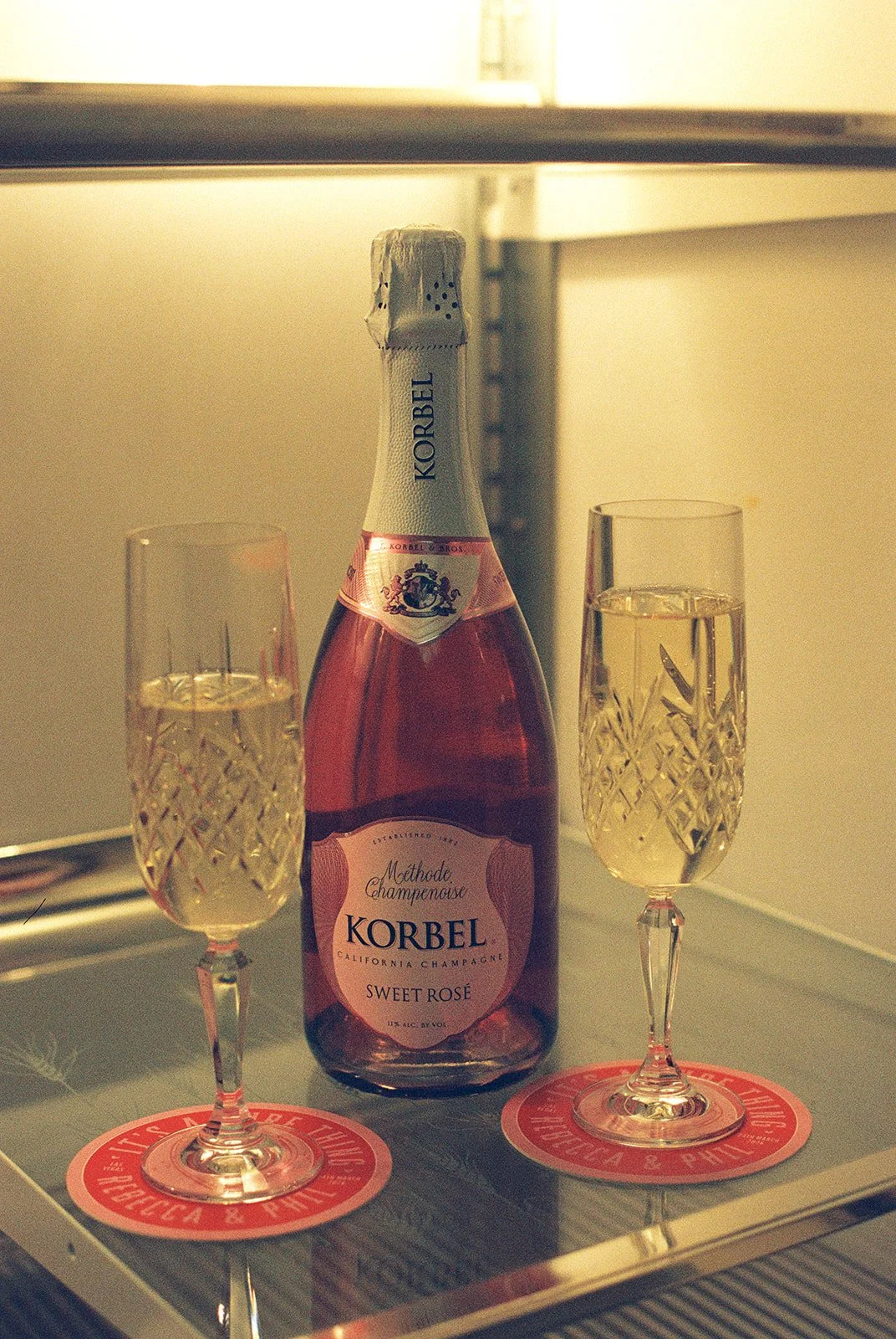 Two glasses of champagne inside of a vintage fridge.
