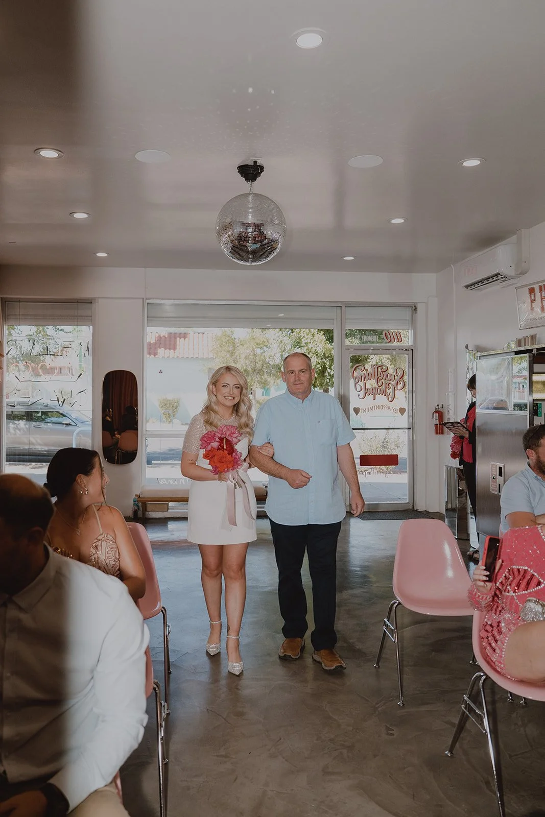 Bride walking down the aisle at Sure Thing Chapel in Las Vegas with her father during a micro wedding ceremony.