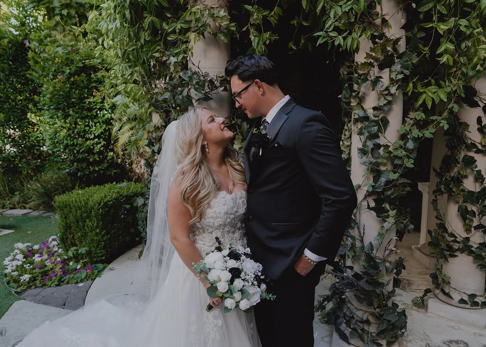 Wide shot of a bride and groom smiling at each other during their Las Vegas micro wedding portraits.