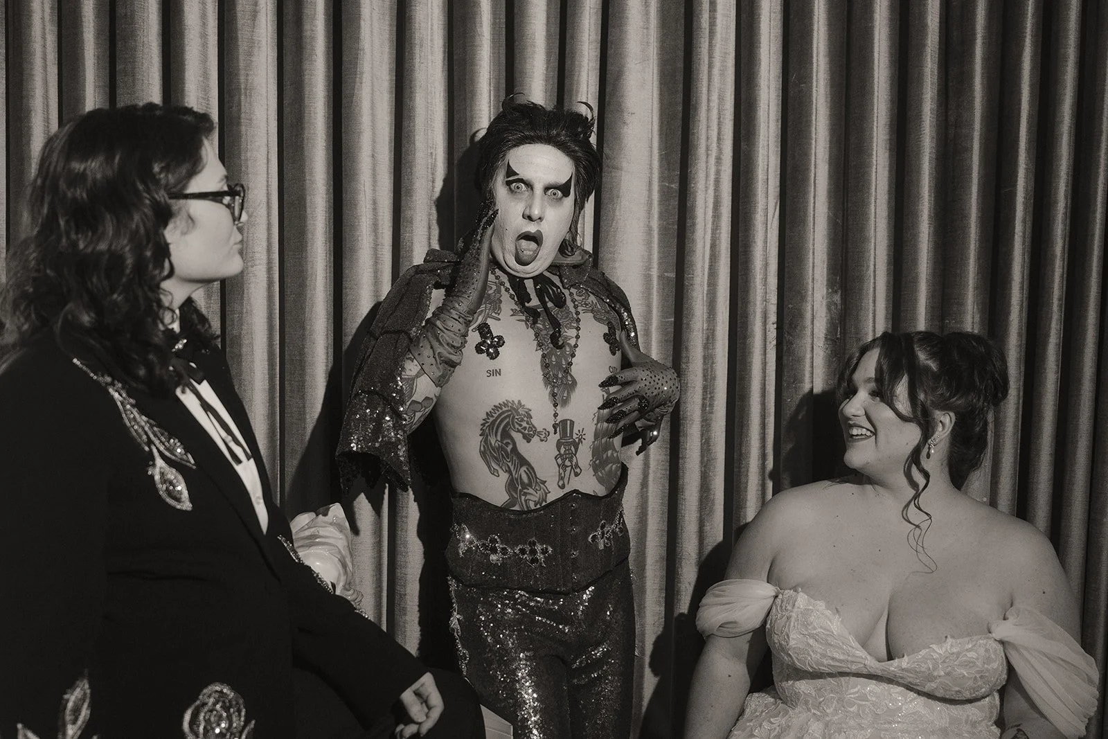 Black and white photo of Hellvis posing with a couple at Sure Thing Chapel.