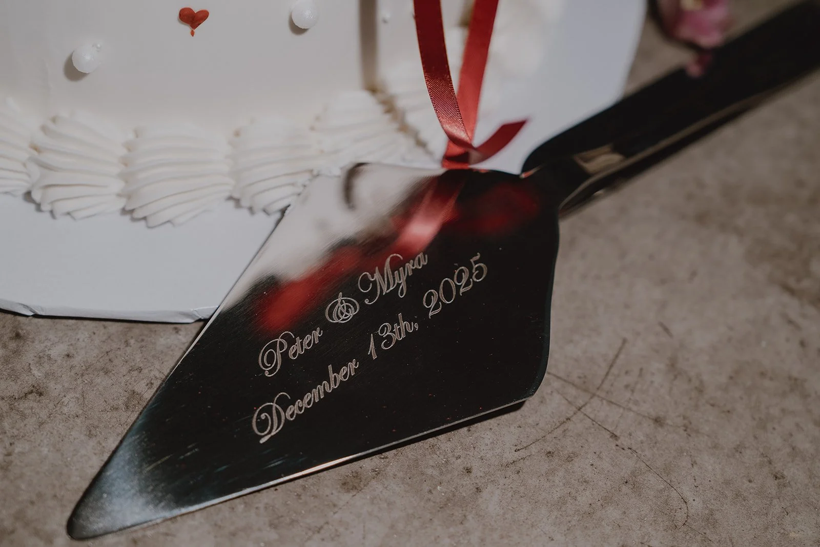 Close up detail shot of a custom cake knife with the bride and grooms name and wedding date.