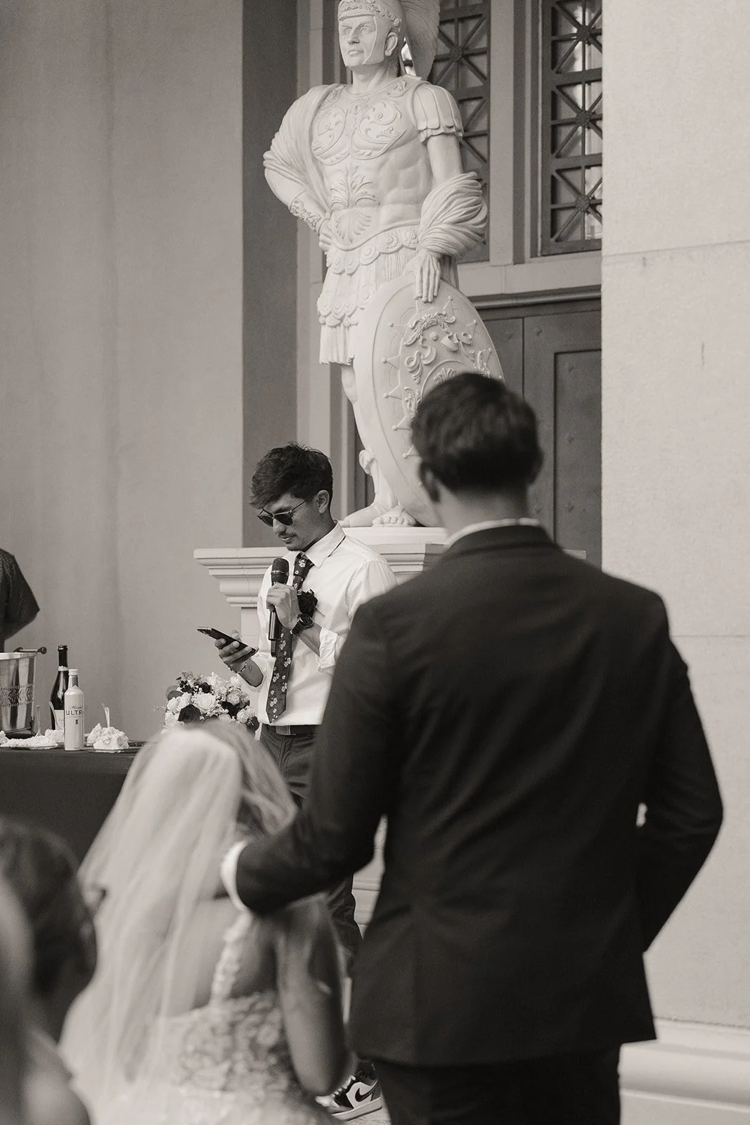 Black and white photo of as bride and groom listening to speeches during their Las Vegas micro wedding