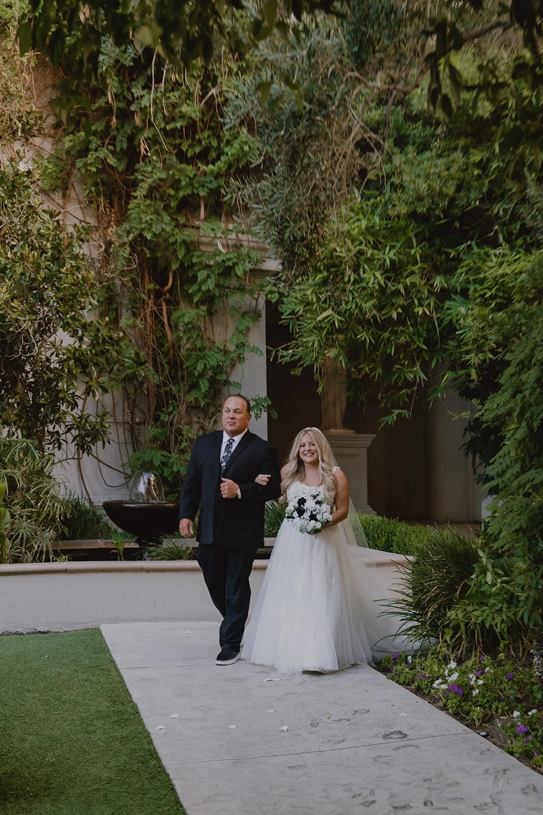 Bride being walked down the aisle by her father for her Caesars Palace Venus Garden wedding ceremony