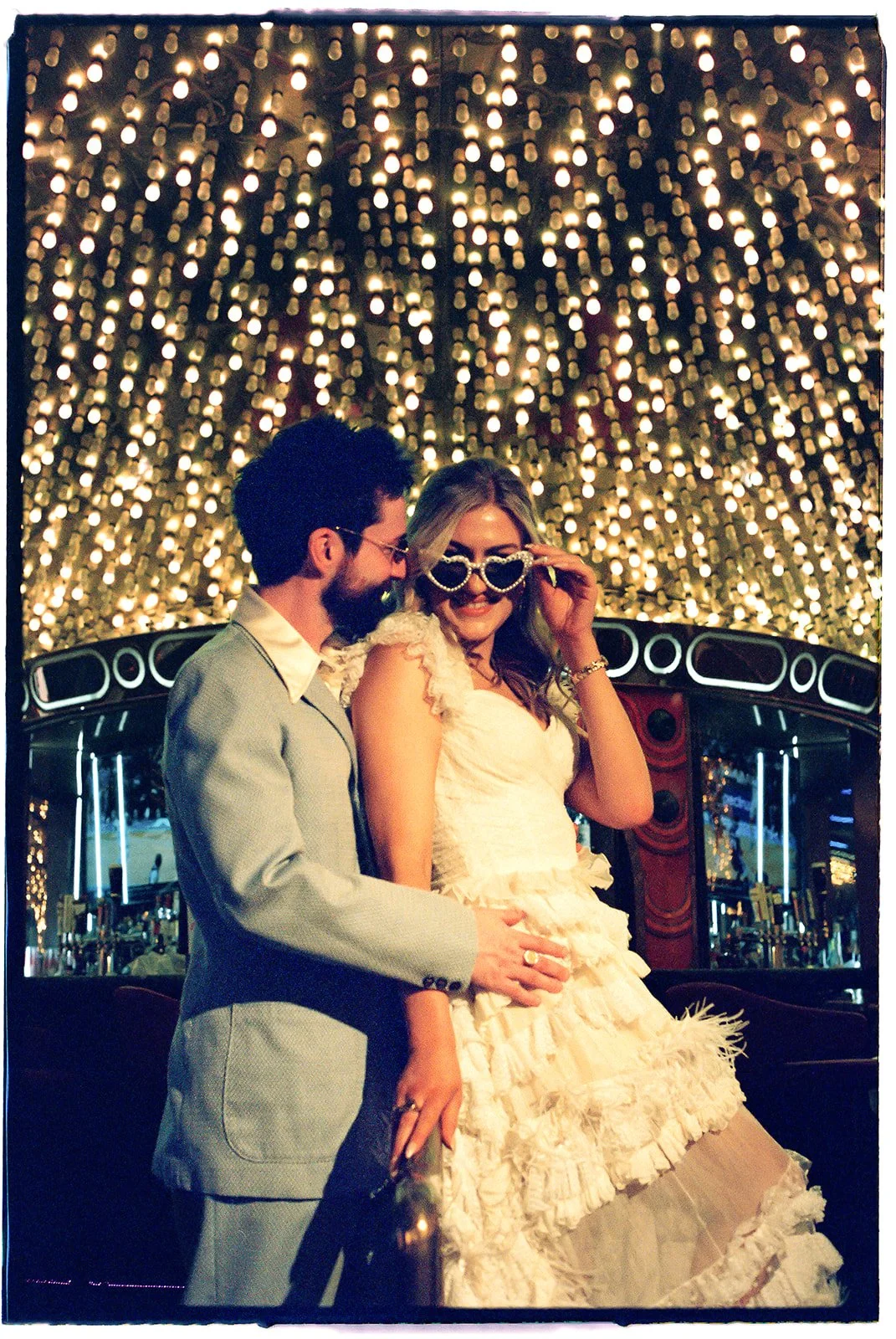 Bride and groom posing in front of Carousel Bar in Las Vegas on 35mm film.