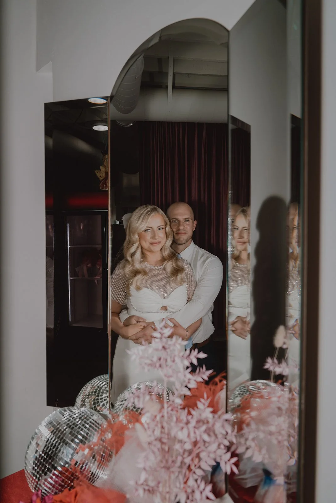 Bride and groom embracing in a mirrored portrait at Sure Thing Chapel in Las Vegas during their micro wedding.