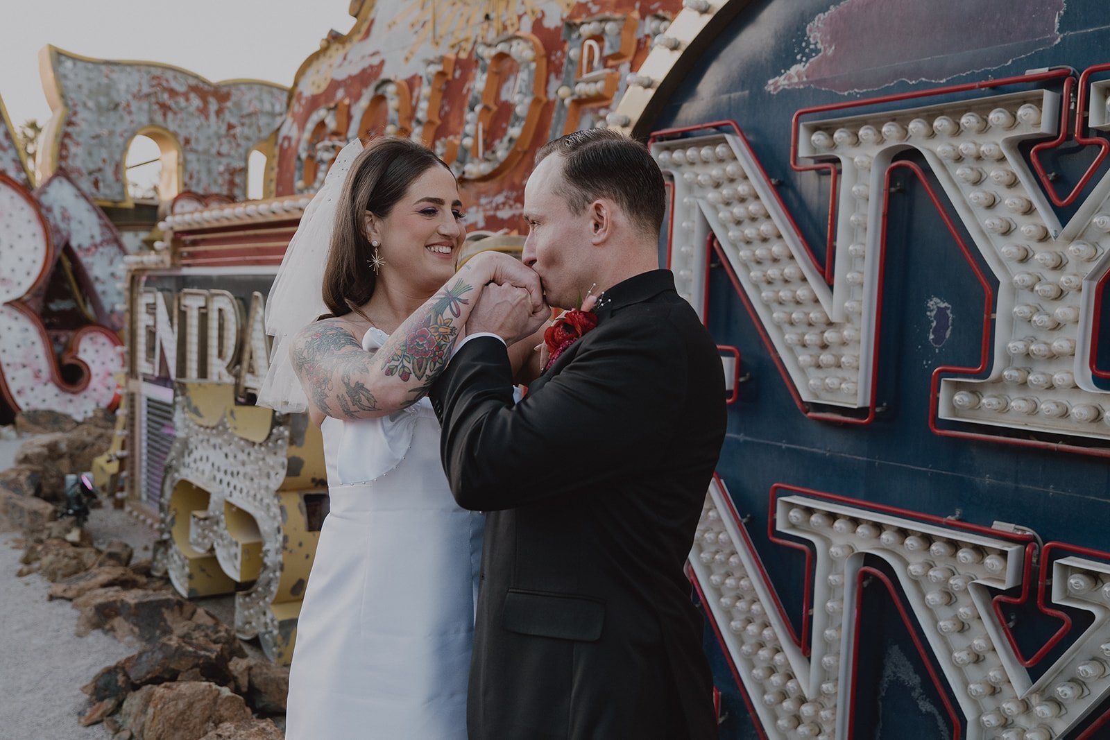 Groom kissing his brides hand during their Neon Museum Las Vegas wedding photos.
