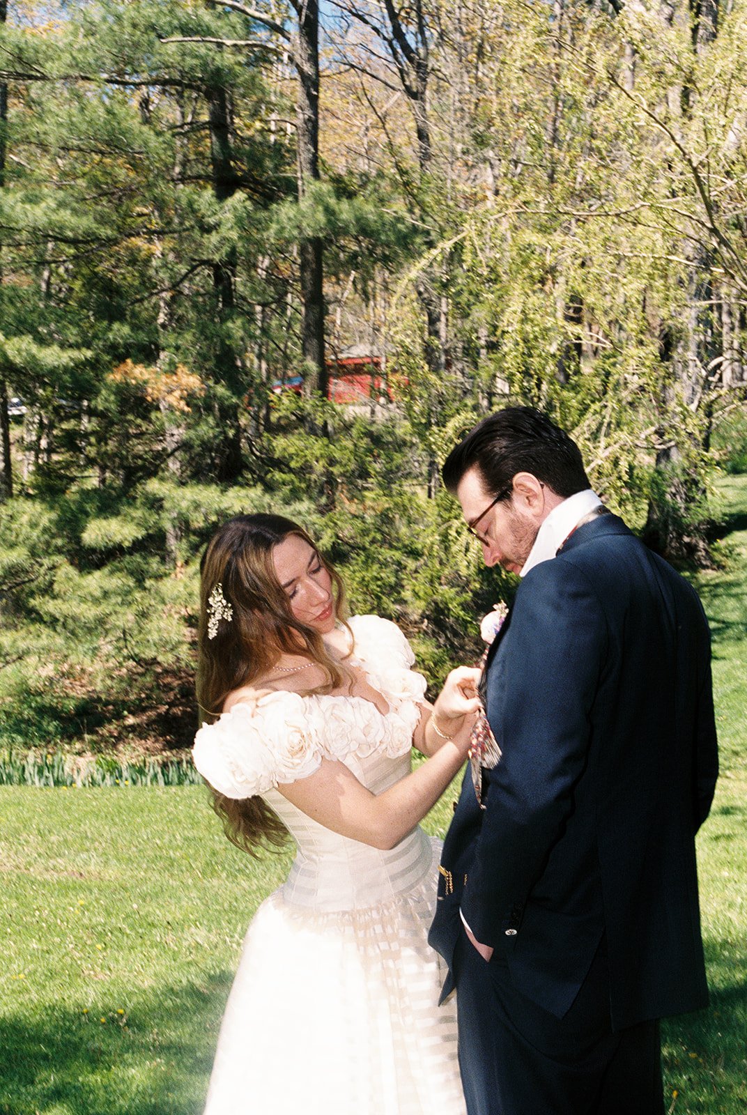 Bride adjusting the grooms tie during their first look outdoors.