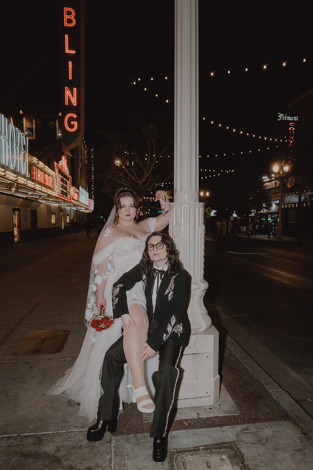 Couple posing for editorial wedding portraits on Fremont Street at night in Las Vegas.