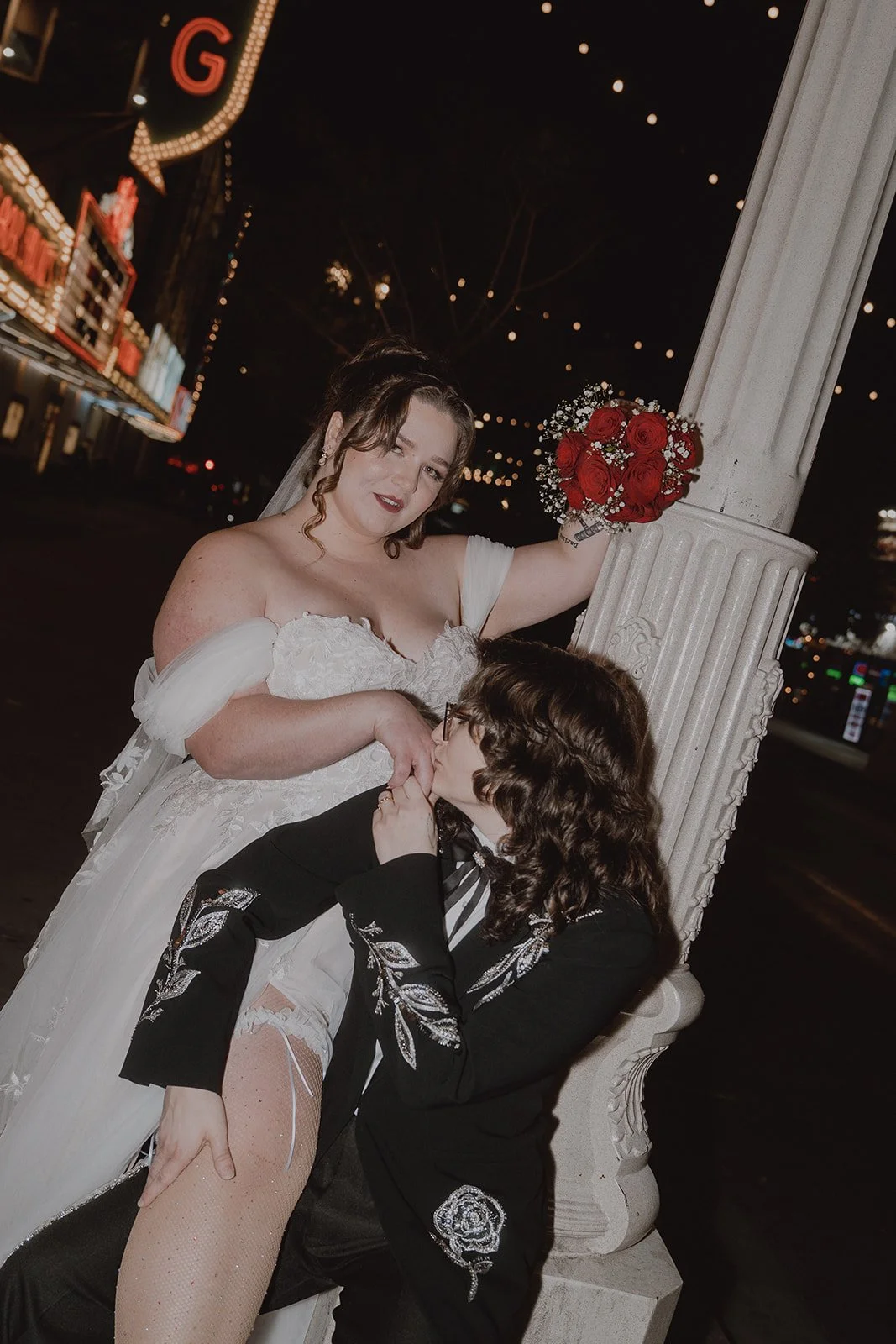 Couple posing for editorial wedding portraits on Fremont Street at night in Las Vegas.