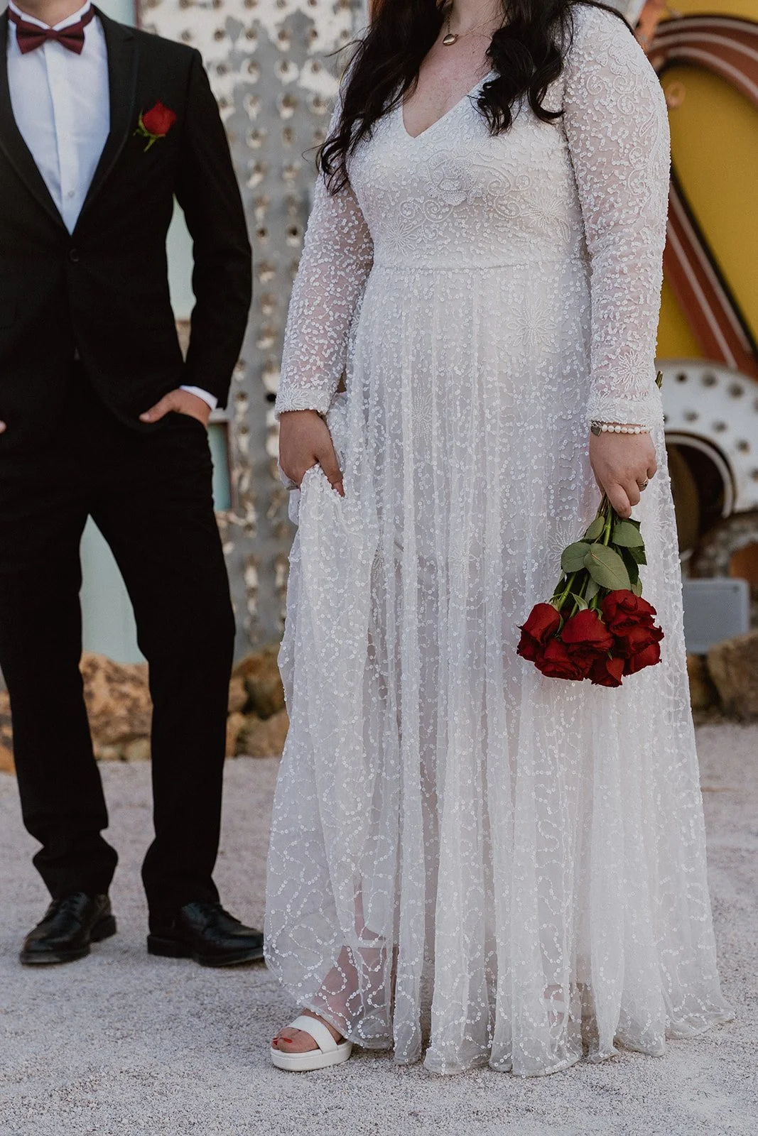 Close up portrait of a bride and groom posing next to one another.