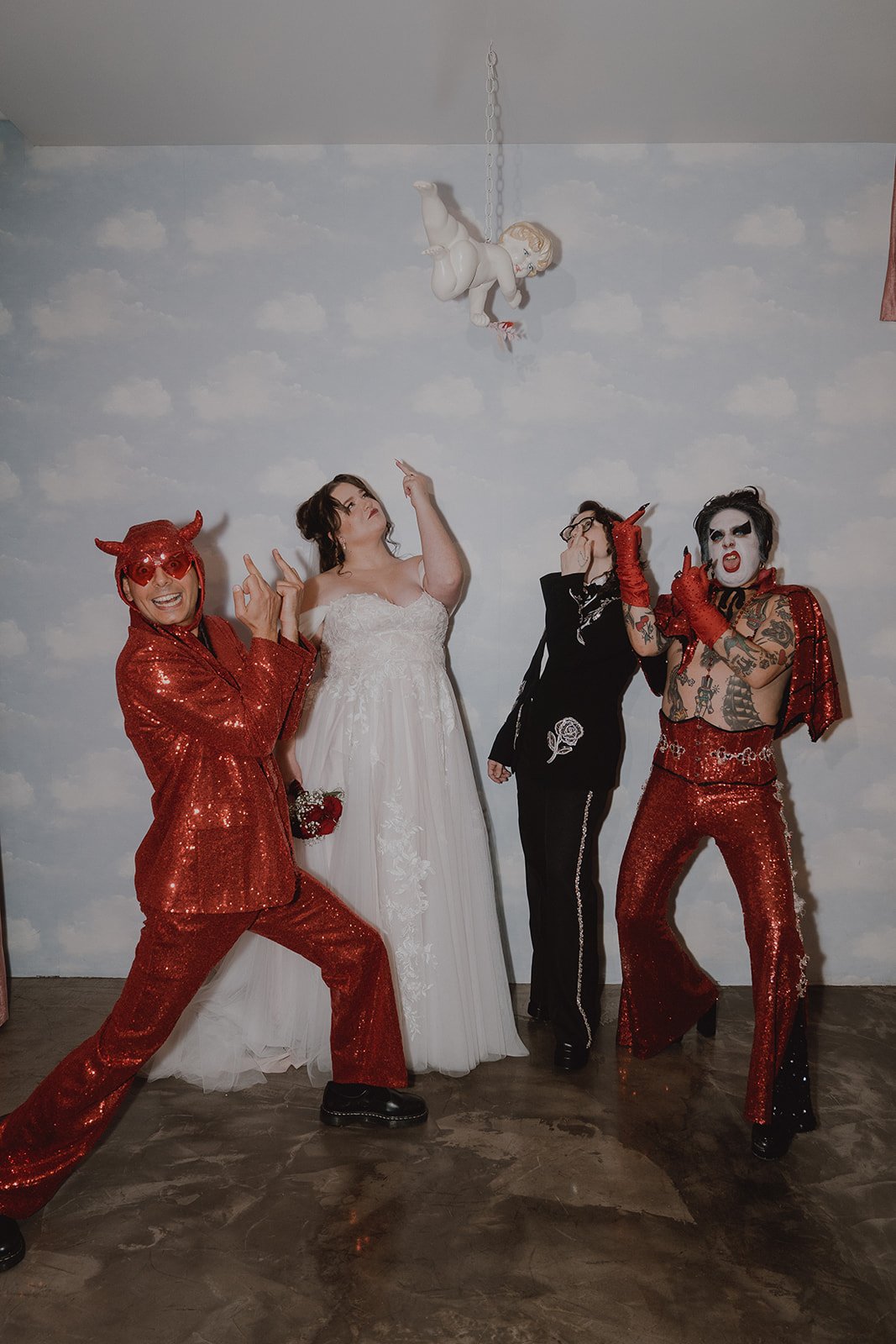 Couple and Hellvis raising their middle fingers to the air during a Sure Thing Chapel wedding.