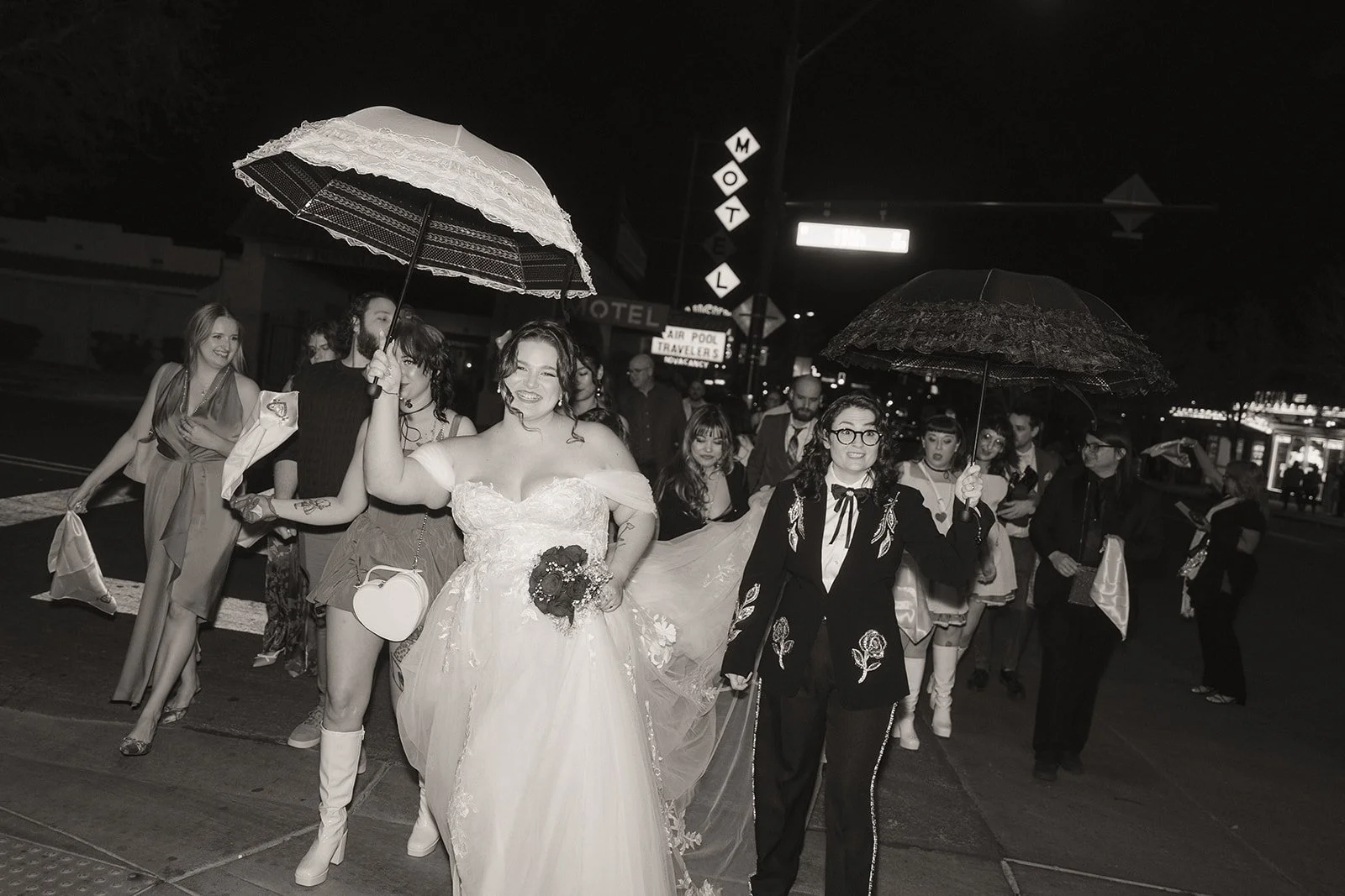 Couple walking through Downtown Las Vegas with their wedding party during a New Orleans style second line parade.