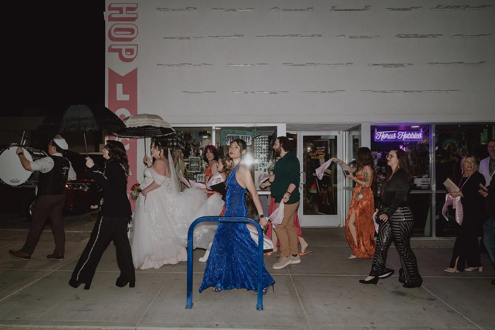 Couple walking through Downtown Las Vegas with their wedding party during a New Orleans style second line parade.