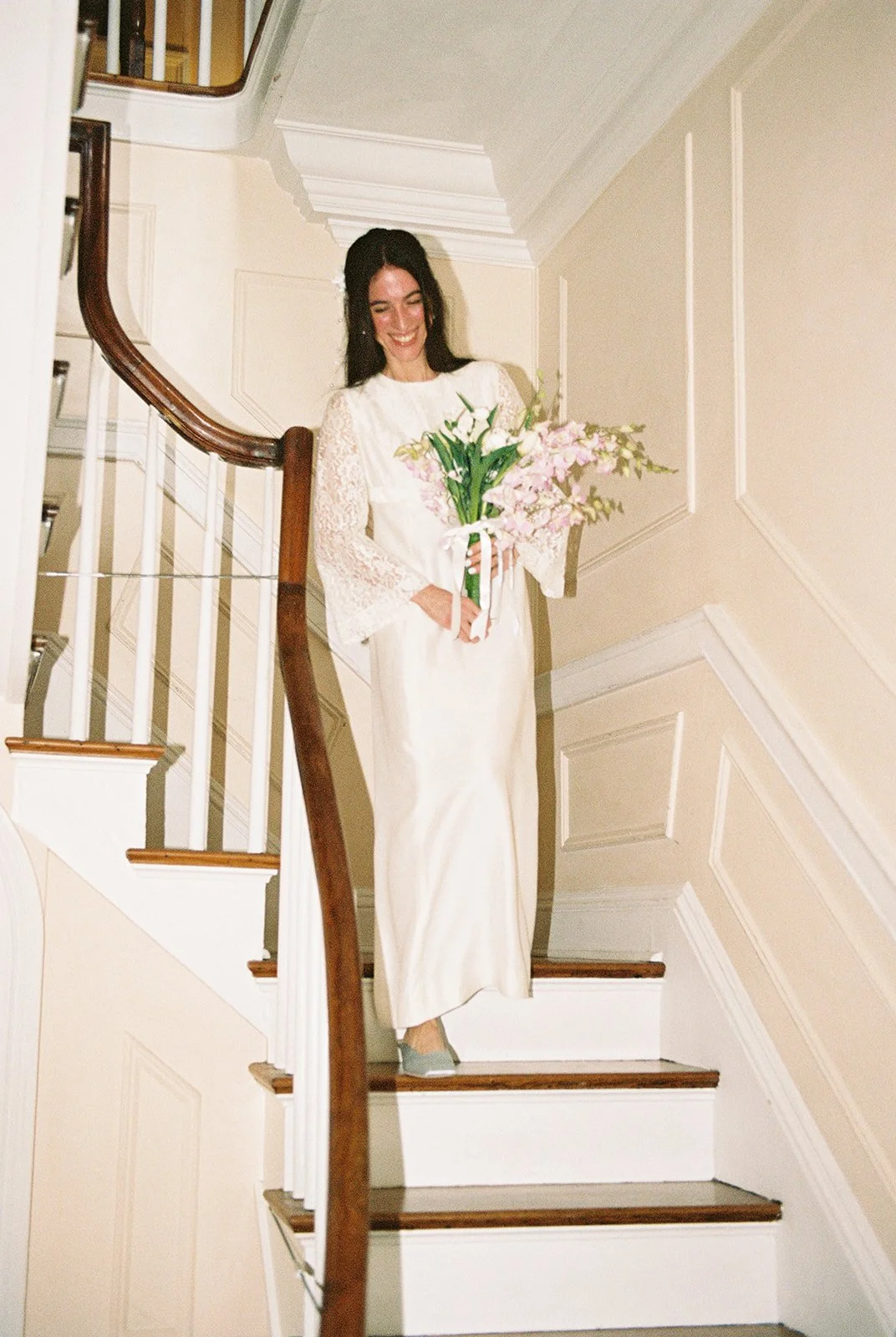 Bride smiling on the curved staircase inside historic Old Town Manor built in 1886 in Key West, Florida.