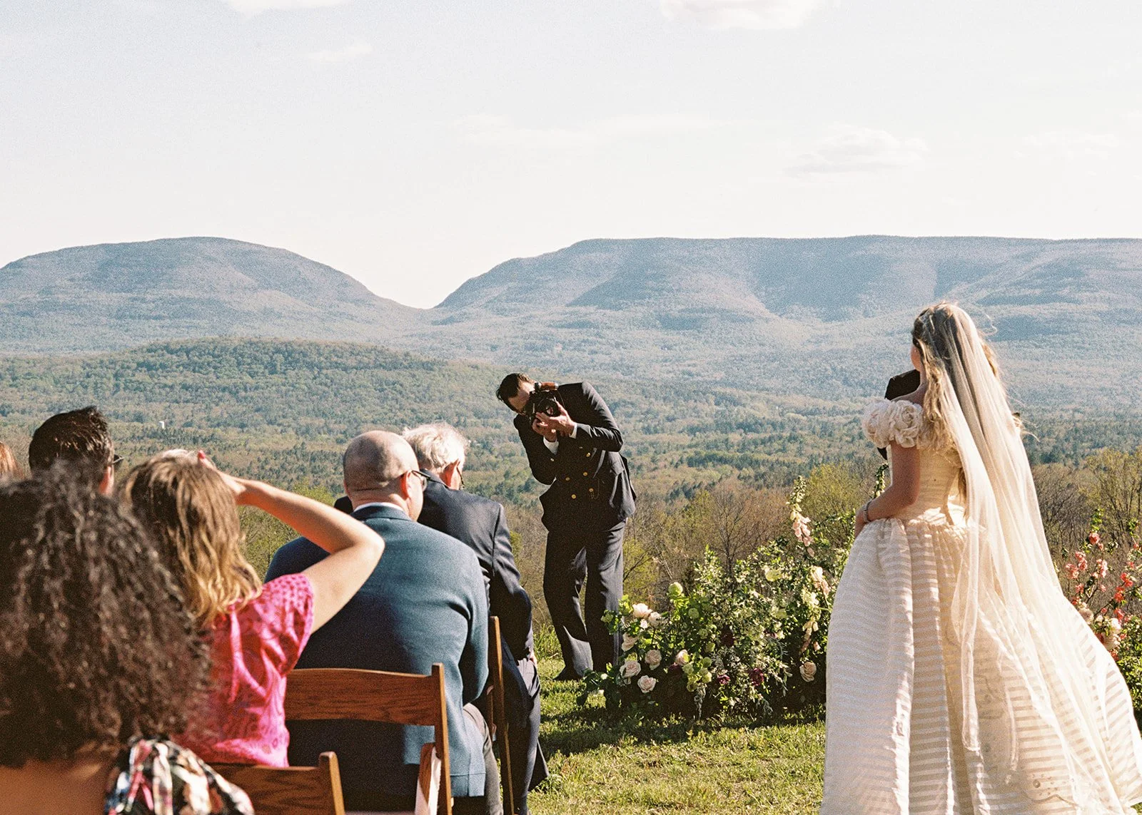 Groom taking a film portrait of the bride during the ceremony.