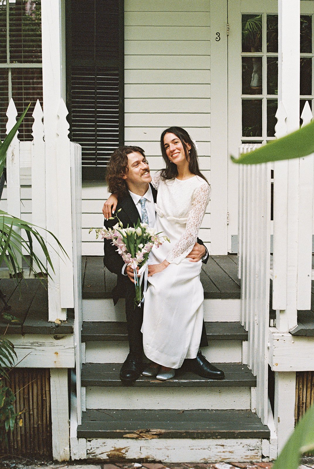 Bride and groom embracing on the front steps of Old Town Manor in Old Town Key West.