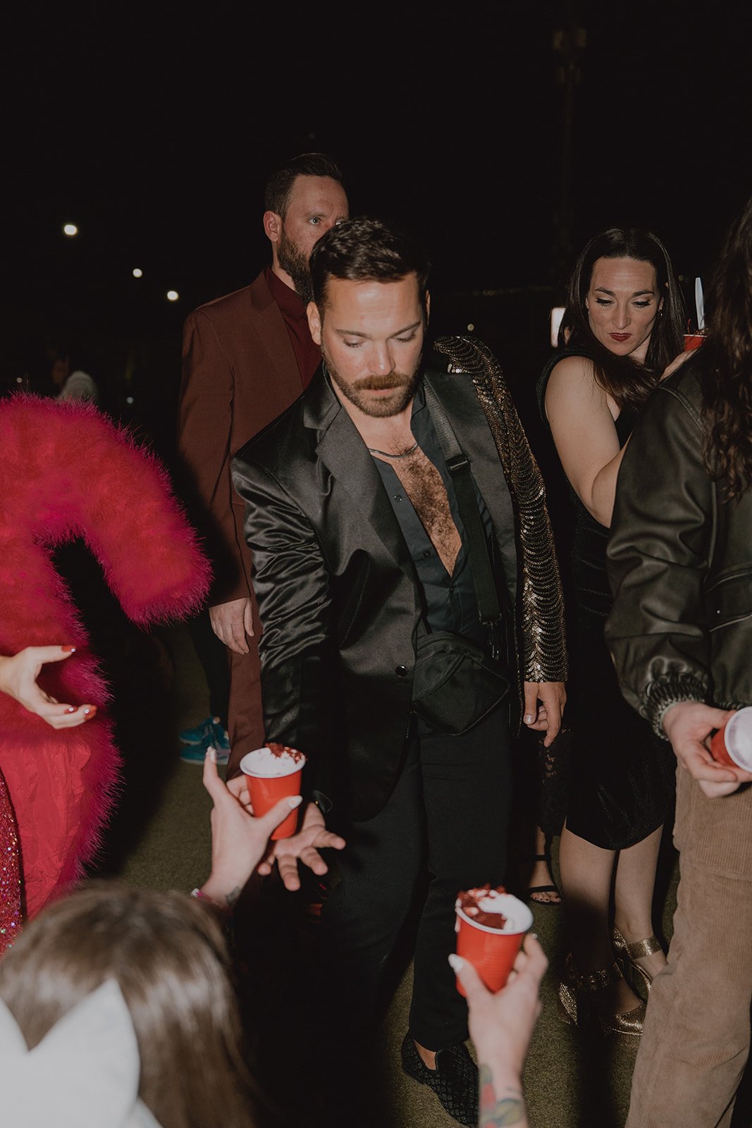 Bride passing guests cake in red solo cups.